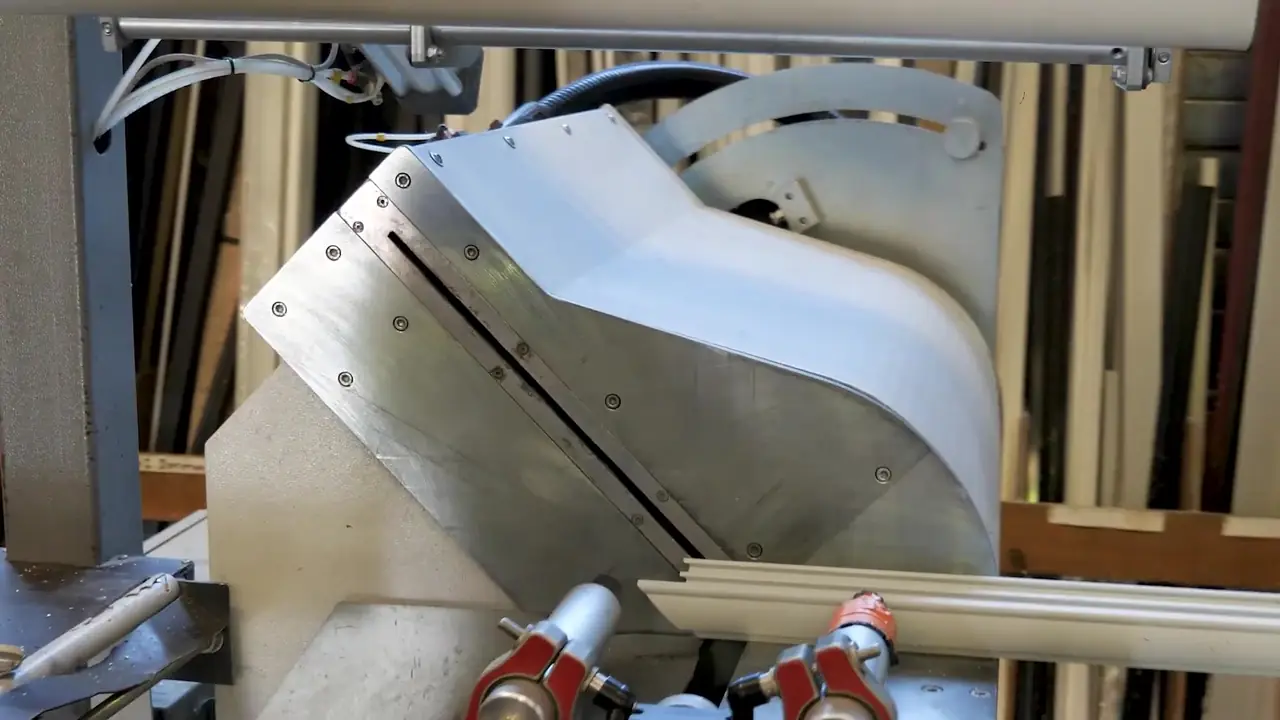 Tête de coupe inclinée d’une machine, profilé maintenu par des brides